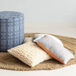 377899-GB__377797-B__377779-B_02_SF_Sarli_poef_grijs_blauw_Orvi_vloerkleed_Lira_kussens_vierkant.webp